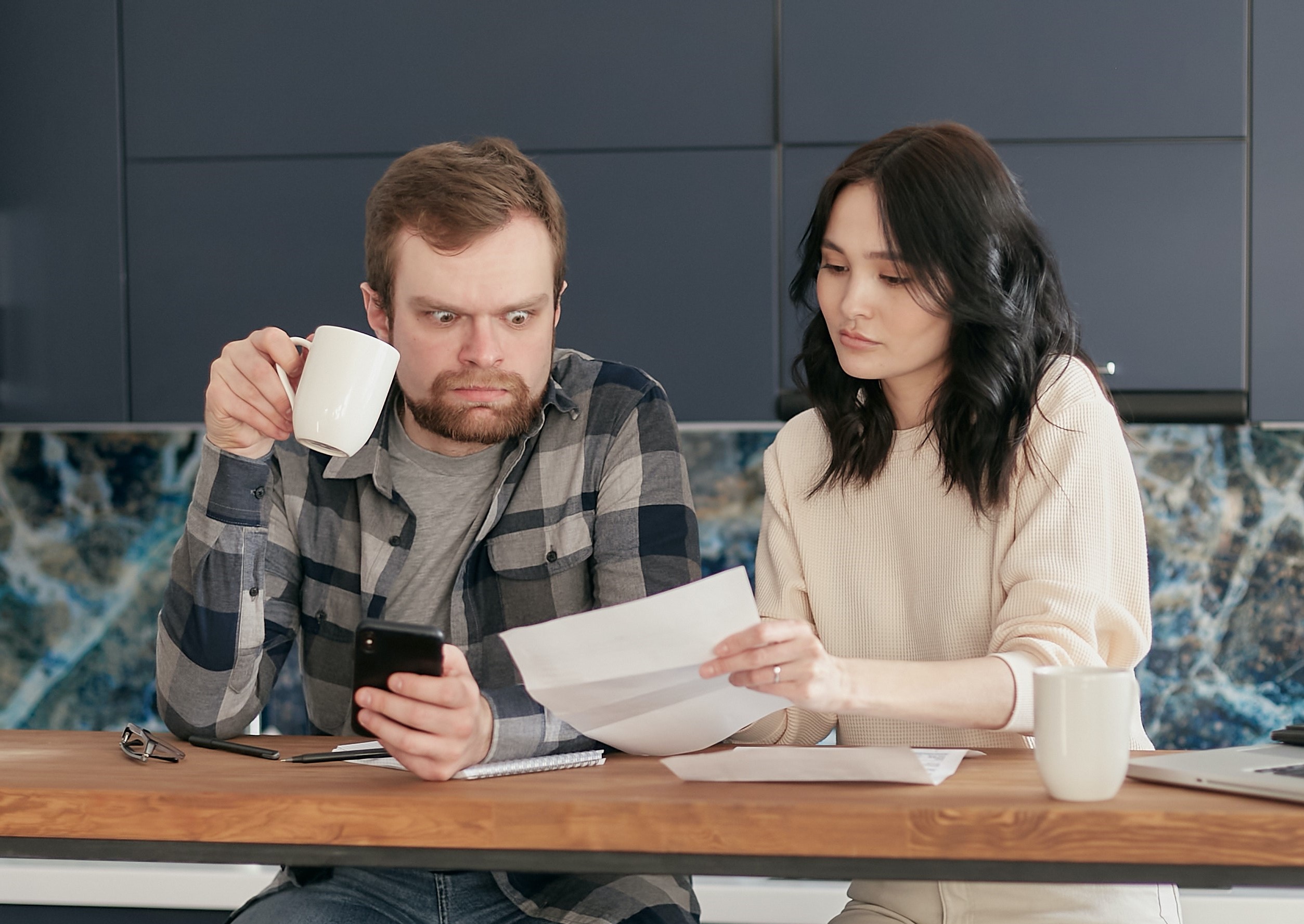 Couple looking at paperwork sitting at a table wondering what is estate planning and why is it important.